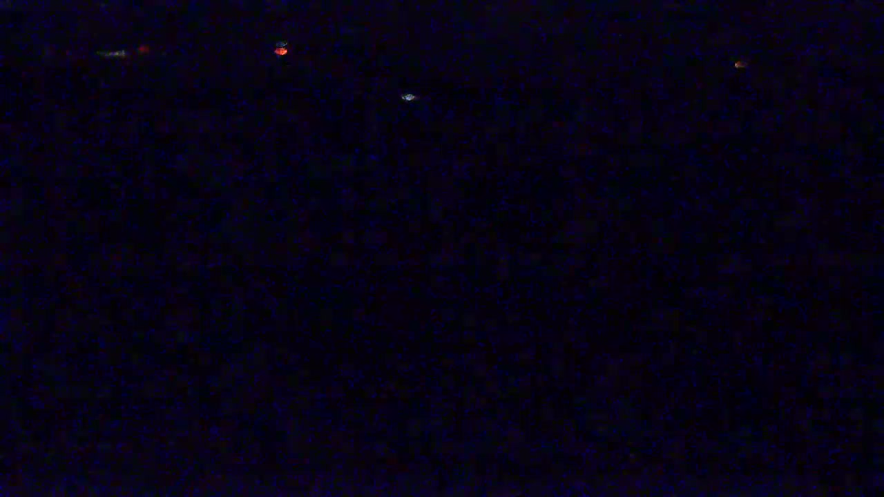 Several small, distant lights are visible in a dark, nighttime scene.