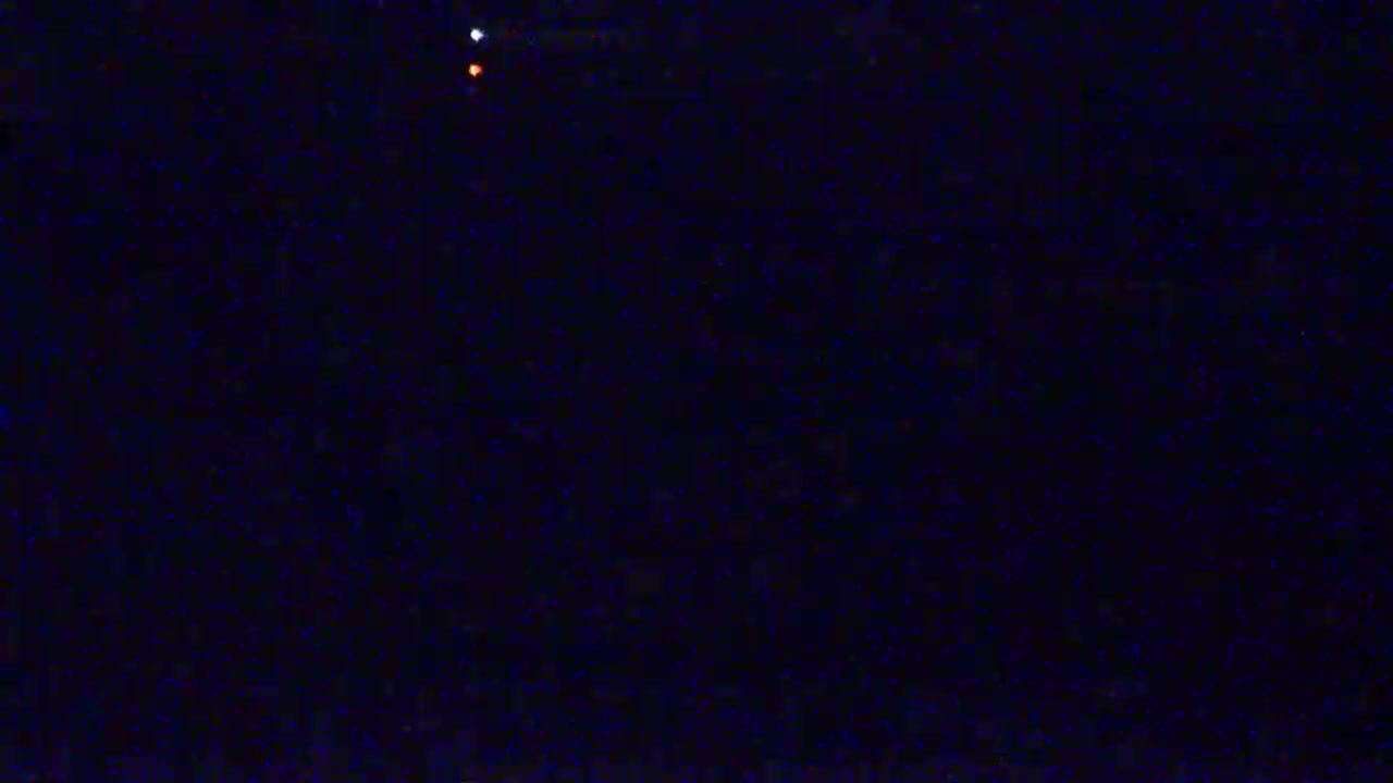 A dark night sky shows a few faint stars, including one brighter, reddish star and one whiter star.