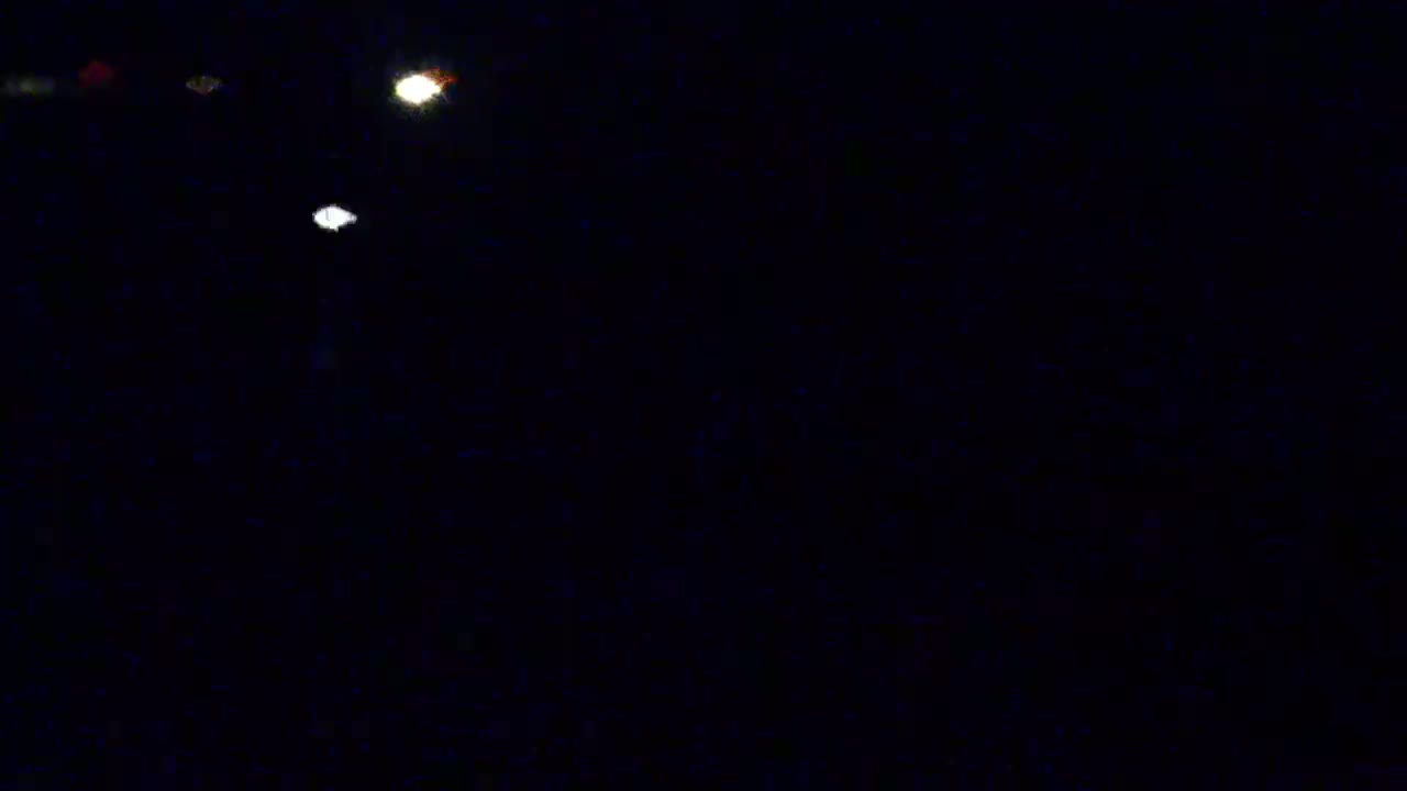 Three bright lights are visible in a dark, nighttime sky.
