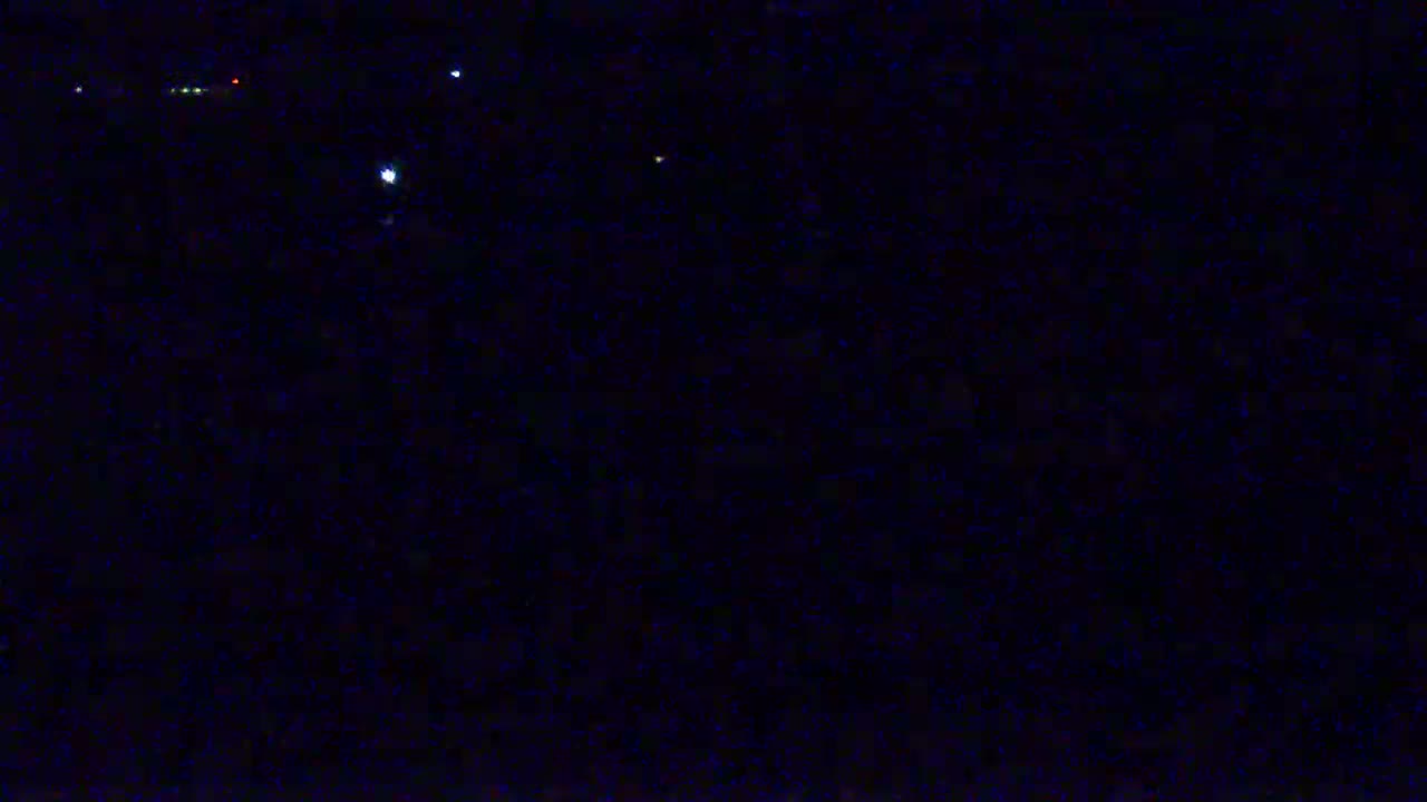 A dark night sky shows a few faint stars and distant lights.
