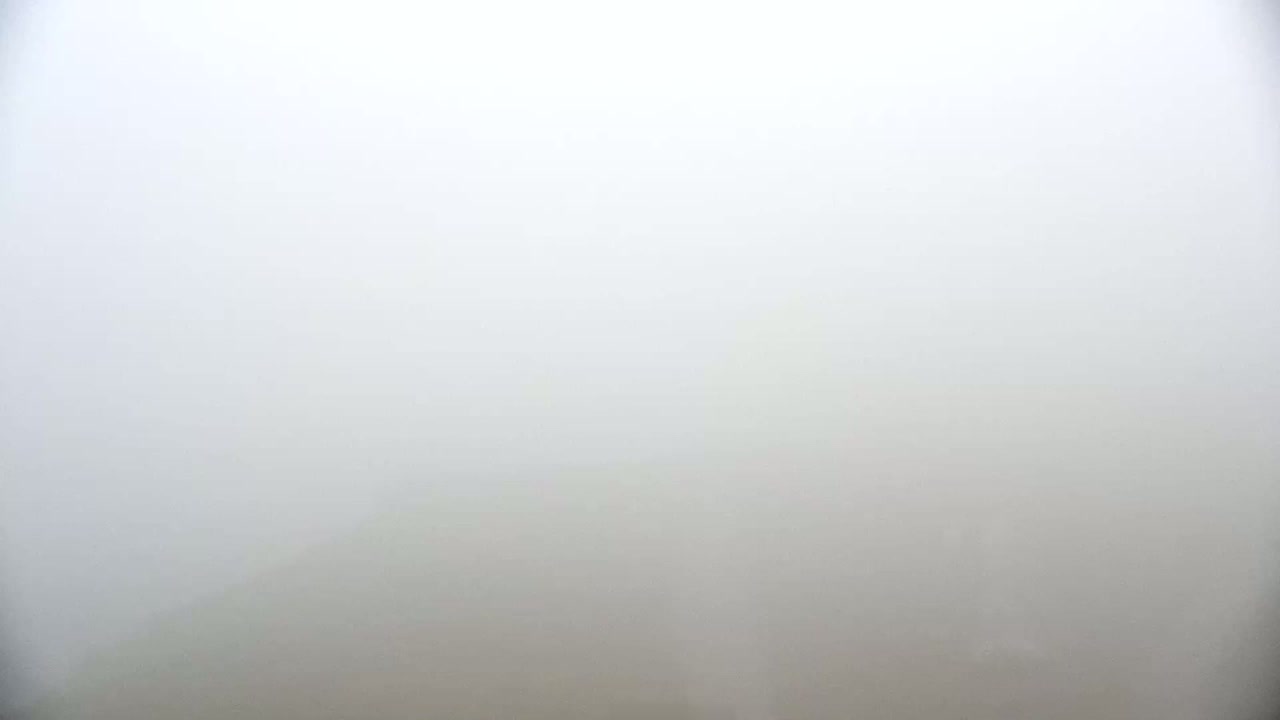 A thick fog obscures the view of the landscape.