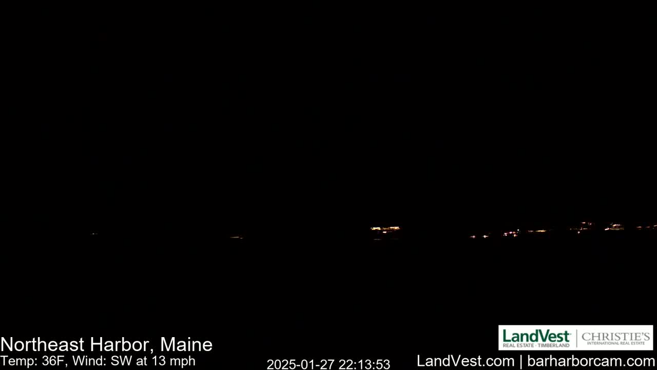 A dark nighttime scene shows a distant line of faint lights, with a southwest wind at 13 mph and a temperature of 36°F.