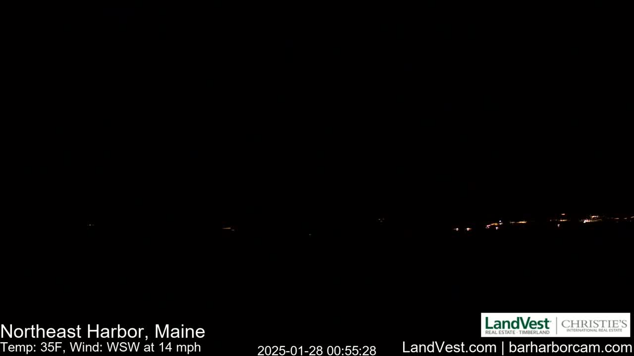 A dark, nighttime scene shows a distant line of faint lights on the horizon, under a clear, dark sky with a 35°F temperature and a 14 mph wind from the west-southwest.