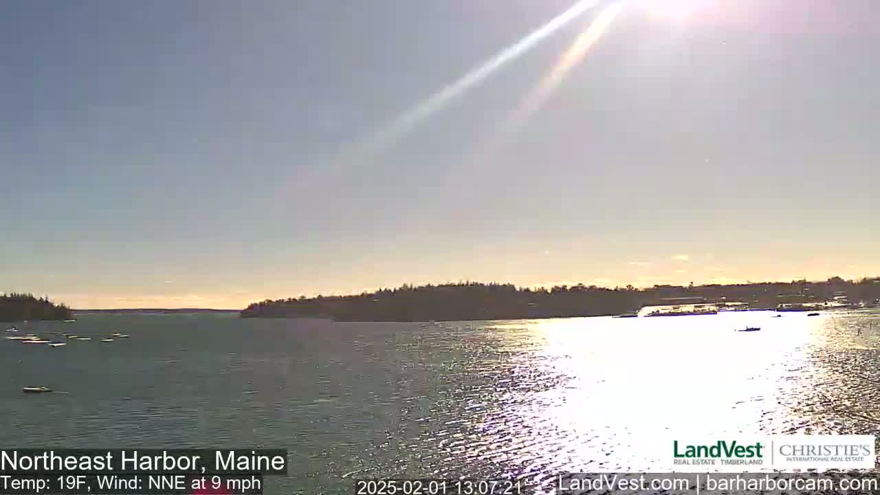 A sunny, cold day with a northeast wind shows a calm harbor with a distant shoreline and a few boats.