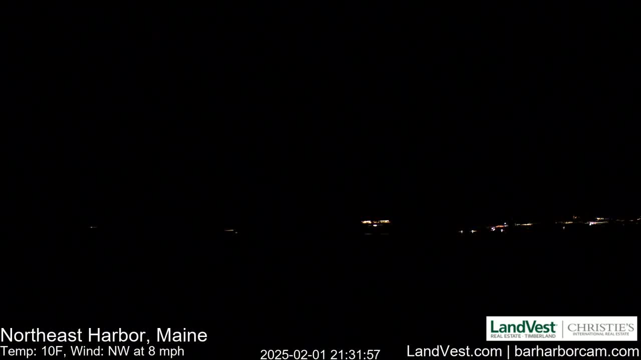 A nighttime, long shot of a dimly lit town under a dark sky with a northwest wind at 8 mph and a temperature of 10 degrees Fahrenheit.