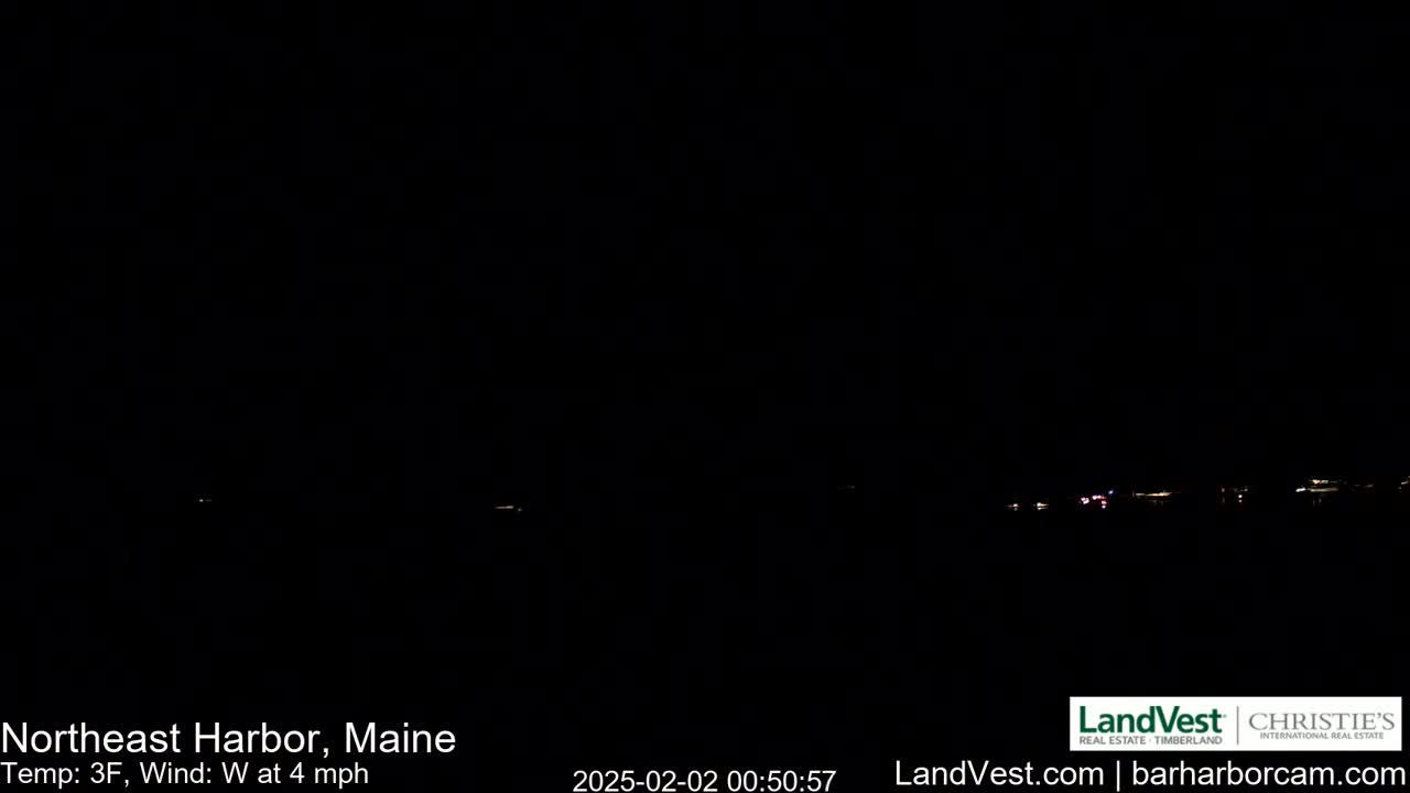 A dark nighttime scene shows a distant line of faint lights across a dark horizon under a clear, black sky, with a west wind at 4 mph and a temperature of 3°F.