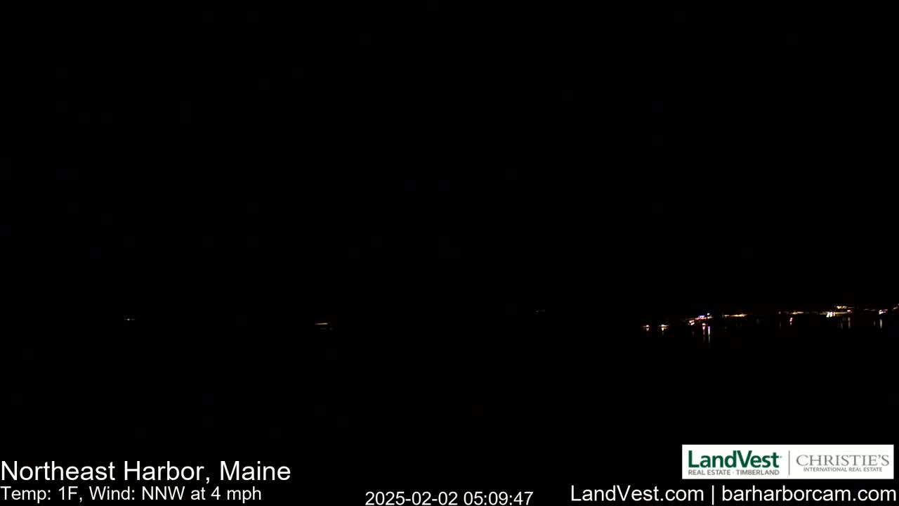 A dark nighttime scene shows a faint line of lights on the horizon across a body of water, with a temperature of 1°F and a north-northwest wind at 4 mph.
