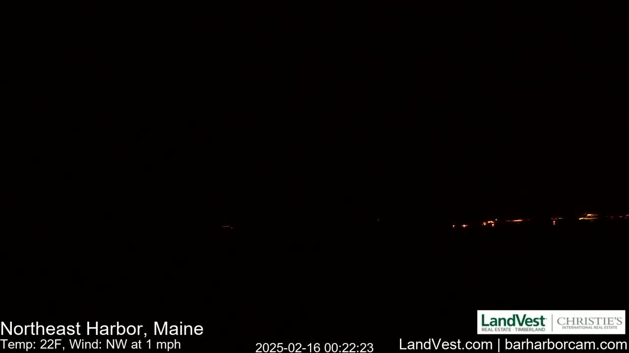 A nighttime, dark landscape with a faint line of distant lights and a 22°F temperature with a 1 mph northwest wind.