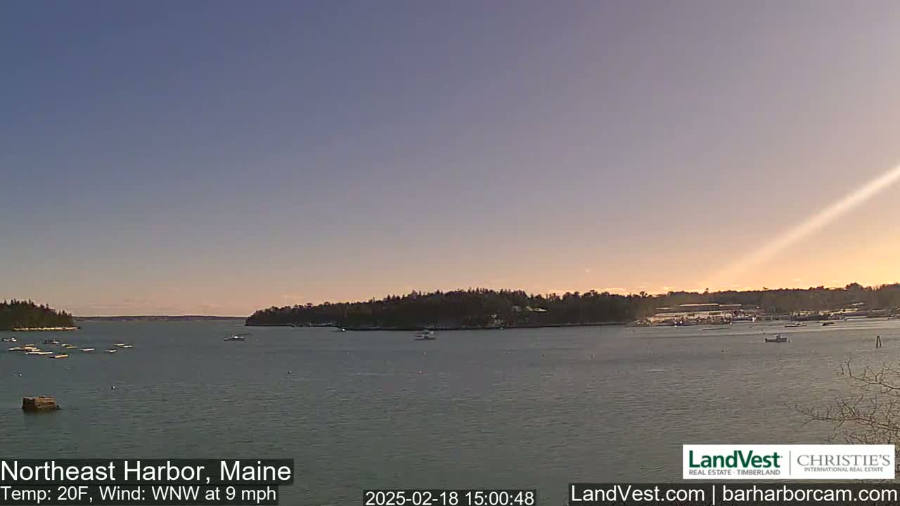 A calm harbor with a few boats, under a clear, twilight sky, with a temperature of 20 degrees Fahrenheit and a west-northwest wind.