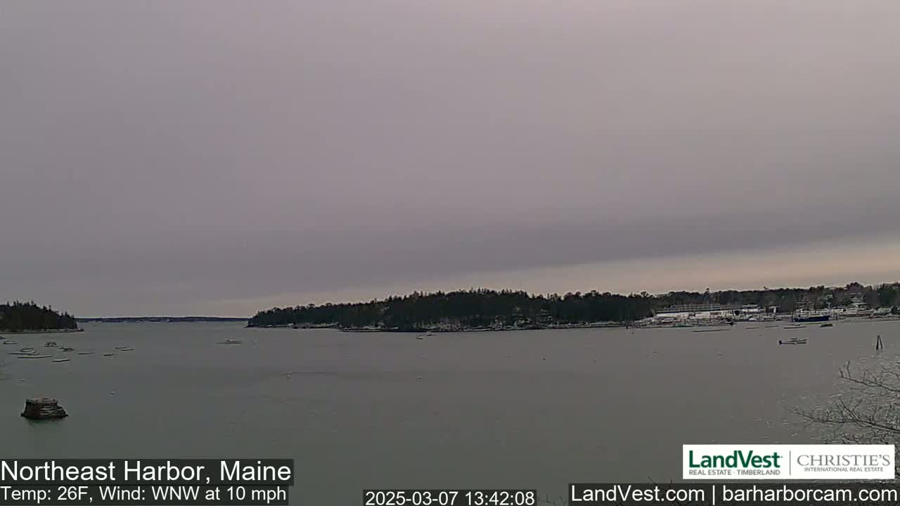A calm harbor is viewed on an overcast day with a temperature of 26°F and a west-northwest wind at 10 mph.