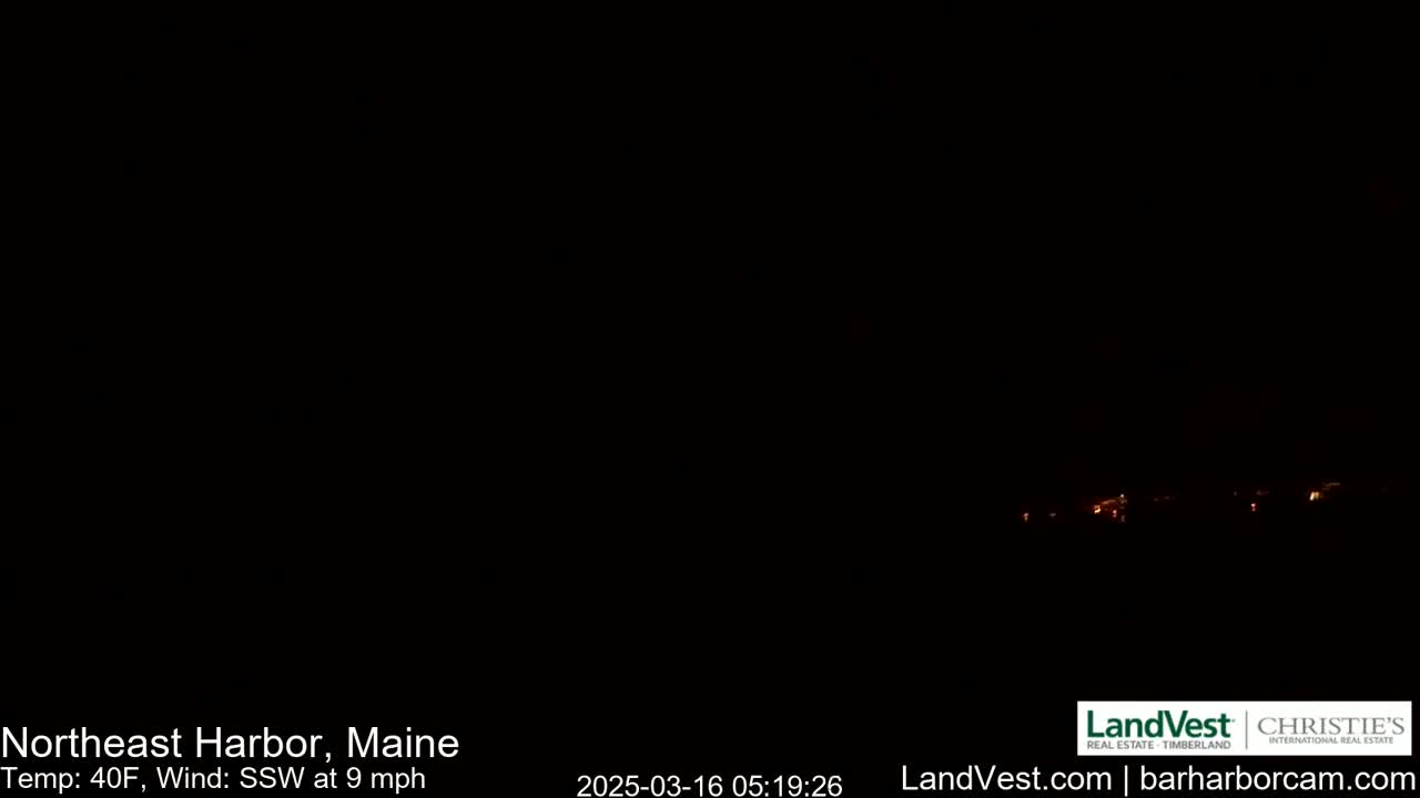 A nighttime, dark view of a distant, dimly lit town with a 40°F temperature and a 9 mph south-southwesterly wind.
