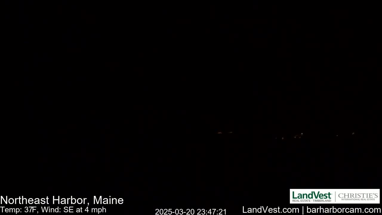 A nearly completely dark nighttime scene shows a few distant, faint lights.
