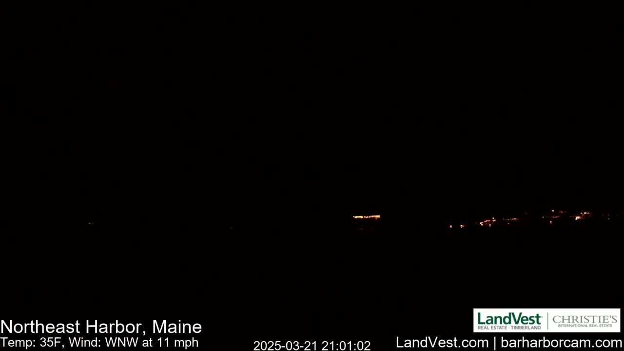 A dark nighttime scene shows a distant line of faint orange lights, with a 35°F temperature and a 11 mph wind from the west-northwest.