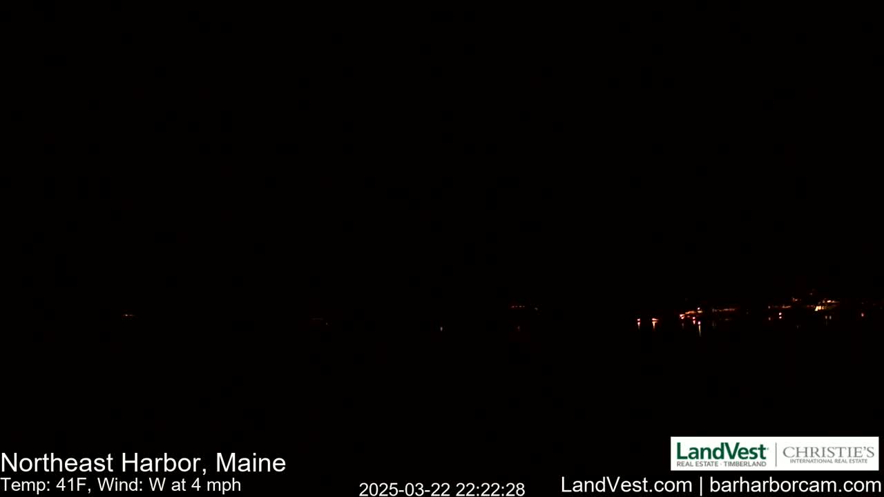 A dark nighttime scene shows a distant shoreline with faint lights, under a clear sky with a temperature of 41°F and a westerly wind of 4 mph.