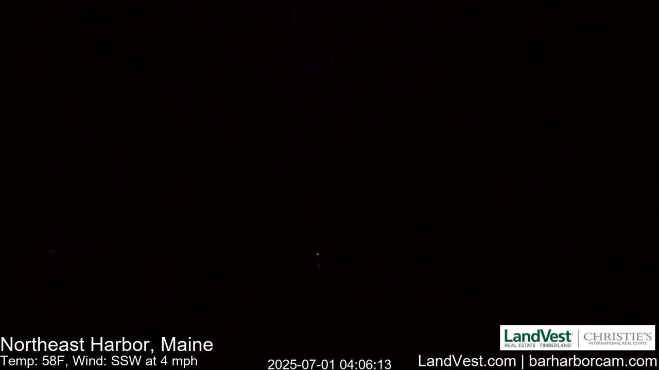 A very dark nighttime image shows a single faint light in the distance.
