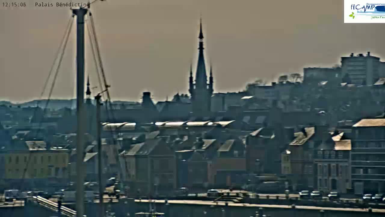A hazy view of a city harbor with a tall spire and numerous buildings, under a muted, sunlit sky.