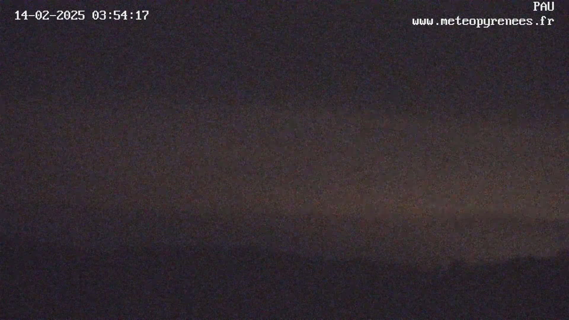 A dark, nighttime scene shows a mostly clear sky with a faint, light-colored horizon.