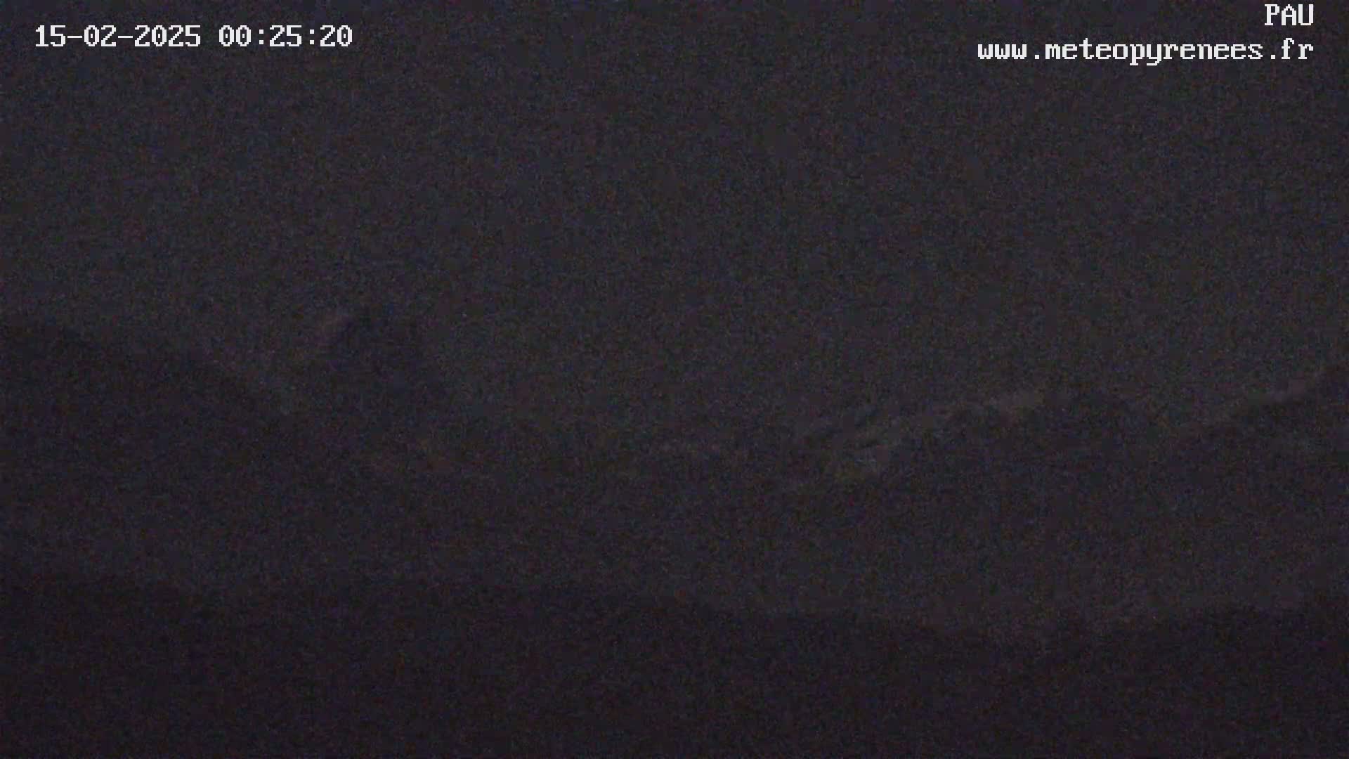 A dark, nighttime image shows a mostly featureless, dark landscape under a clear, dark sky.