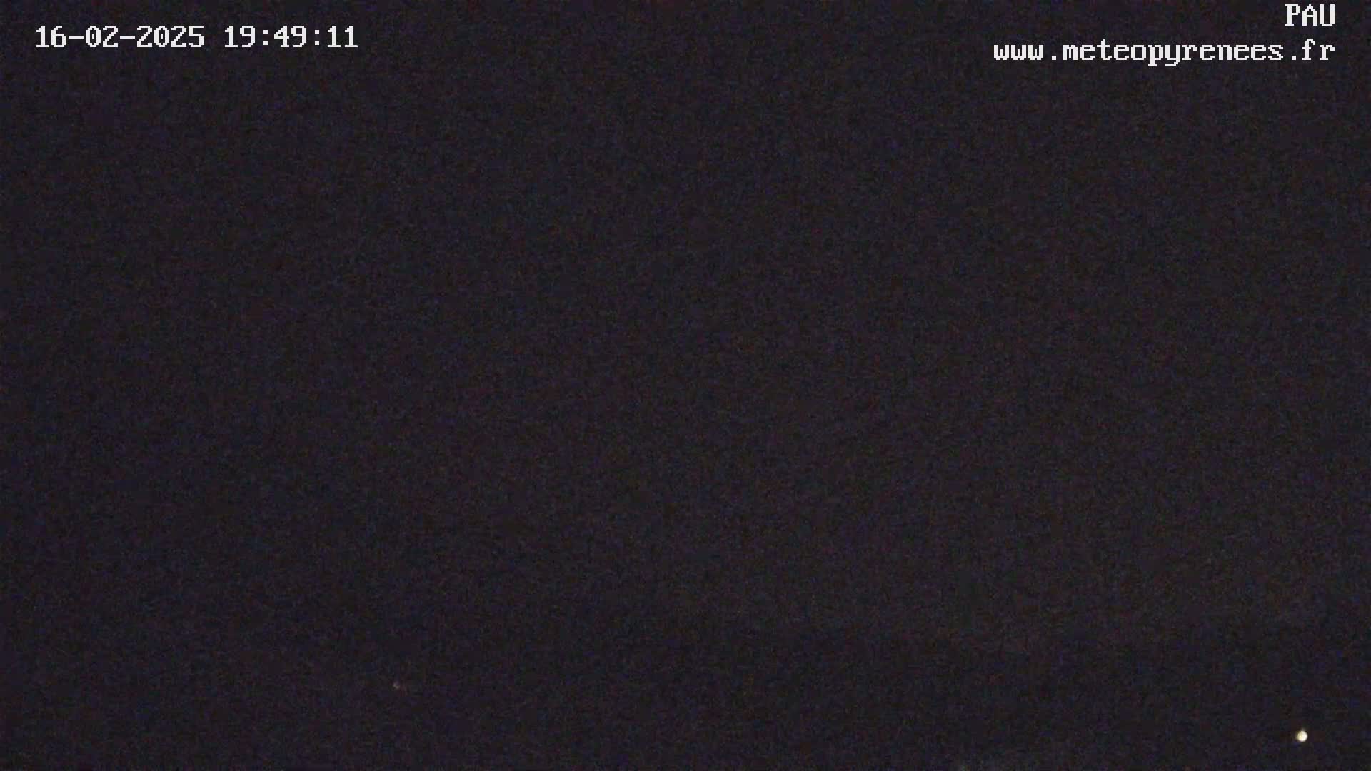 A dark, night sky is visible, with a few faint lights in the distance.