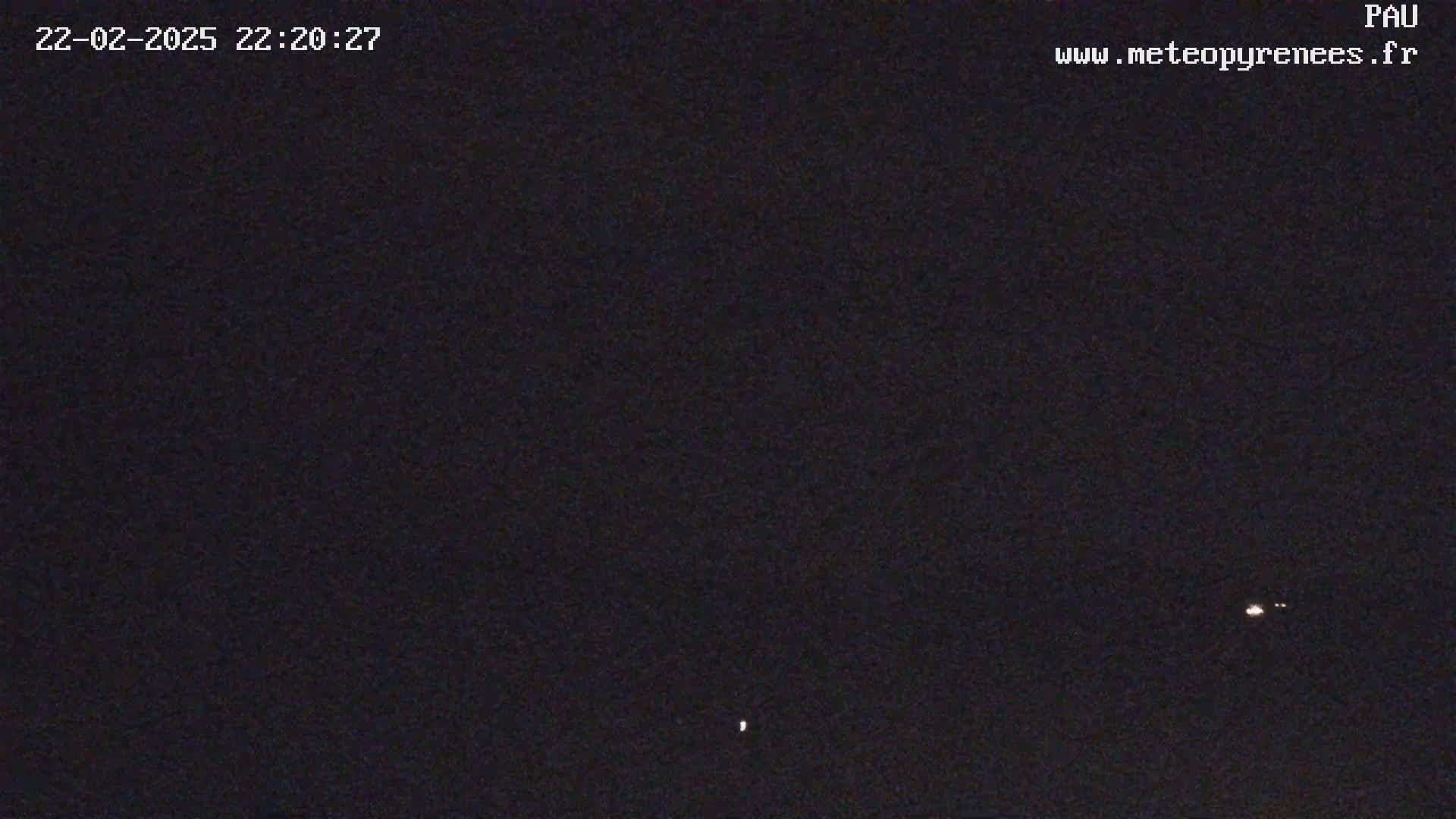 A dark nighttime scene shows a few distant lights in the sky.