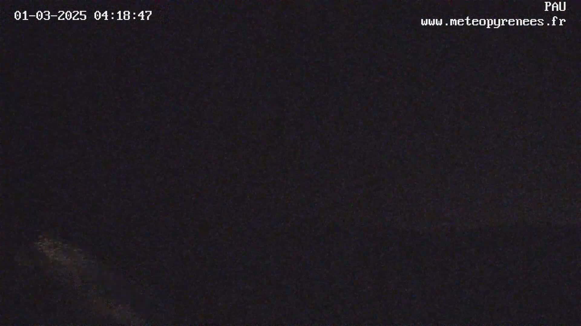 The image shows a dark, nighttime scene with a faint, blurry light source visible in the lower left corner.