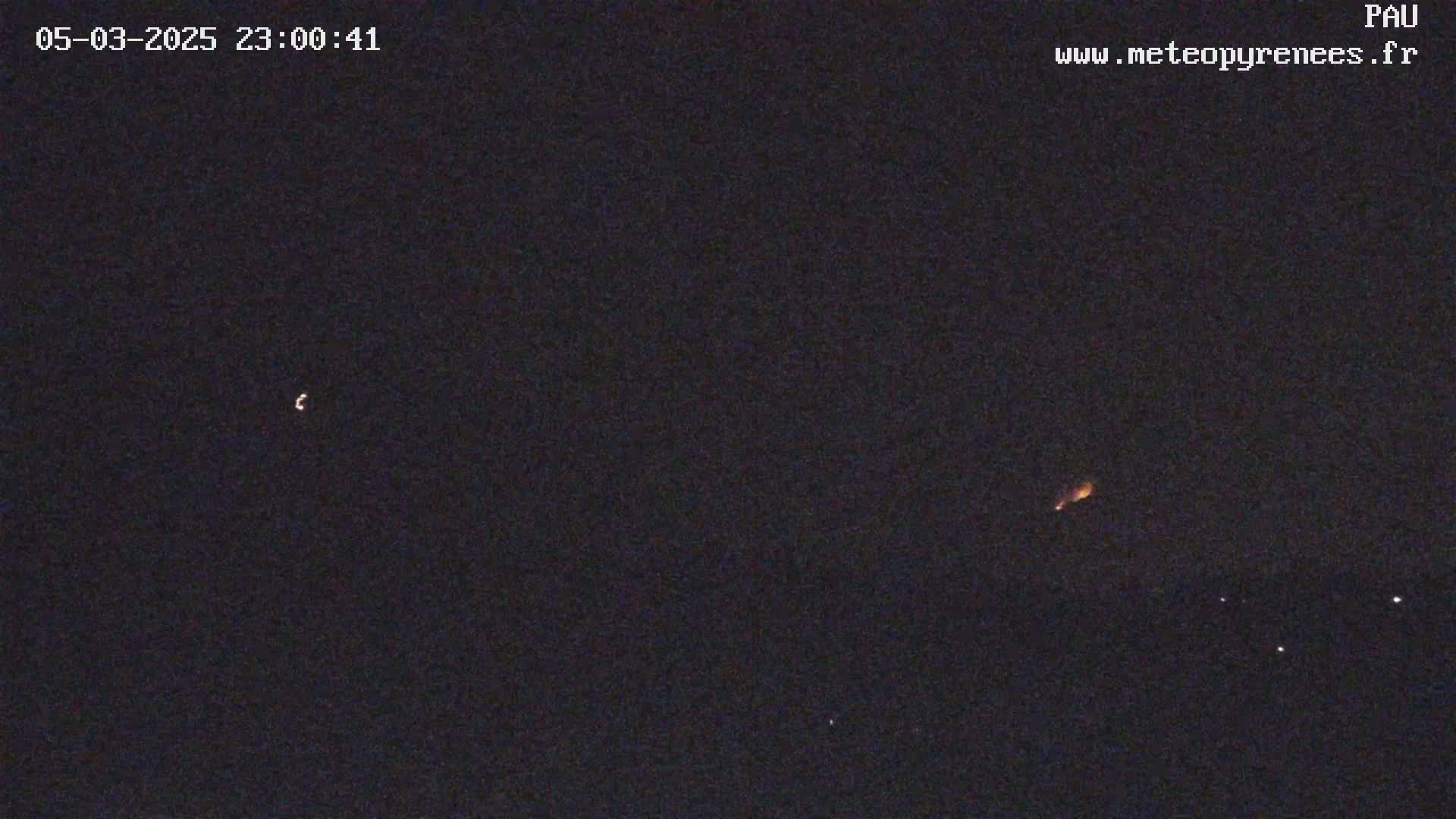 A nighttime image shows a crescent moon, a streak of light possibly from a meteor, and several faint lights in the dark sky.