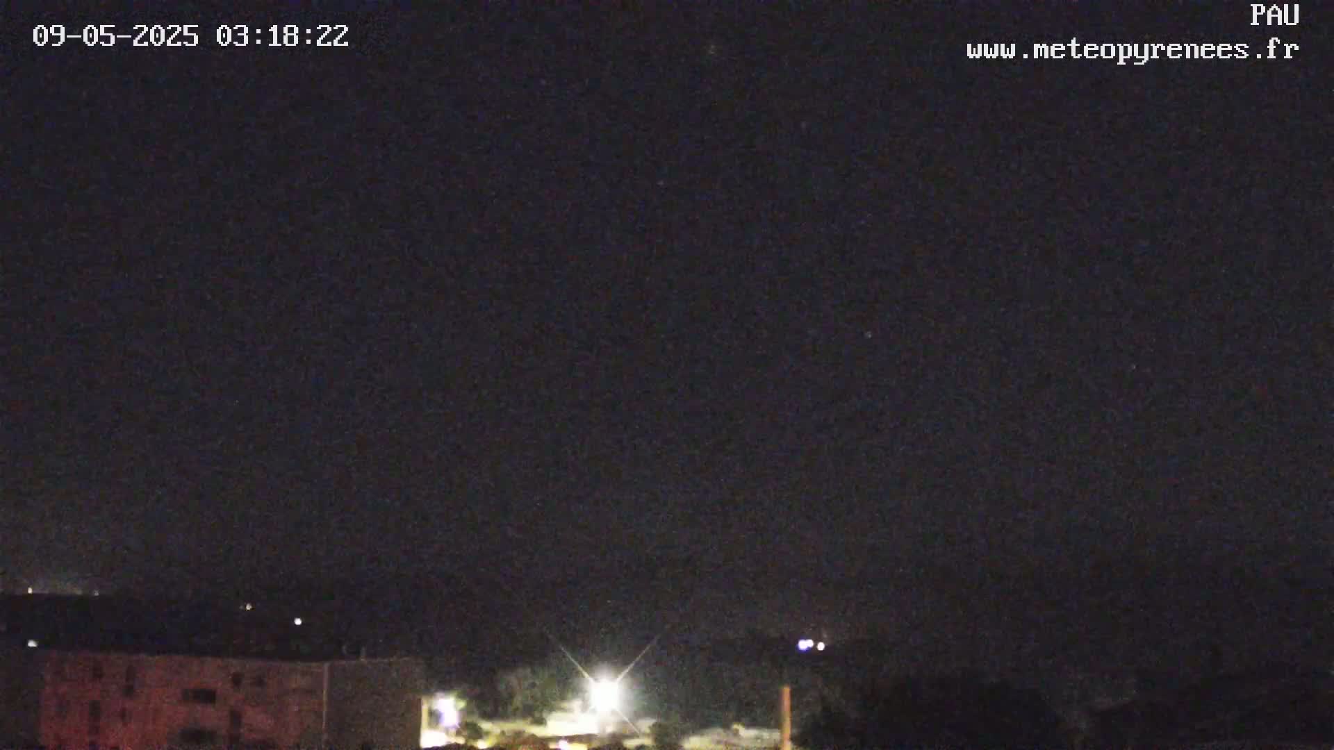 A nighttime view shows a dark sky over a city with a few distant lights.
