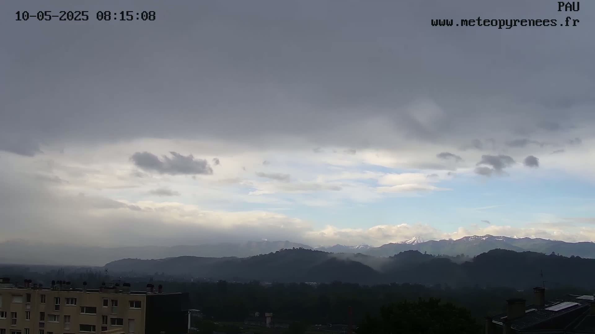 A view of distant, hazy mountains under a mostly cloudy, overcast sky.