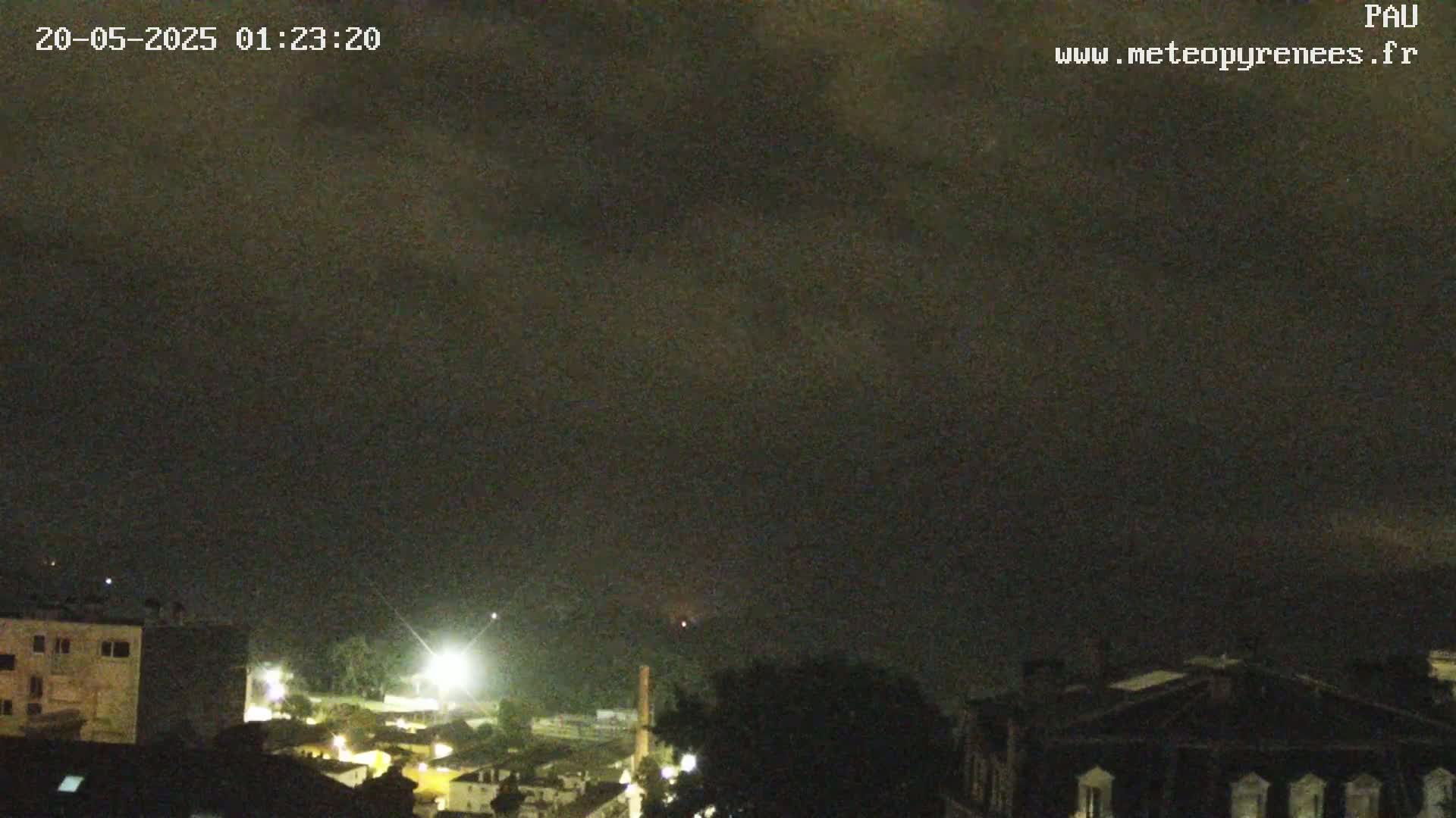 A nighttime view of a town under a dark, cloudy sky.