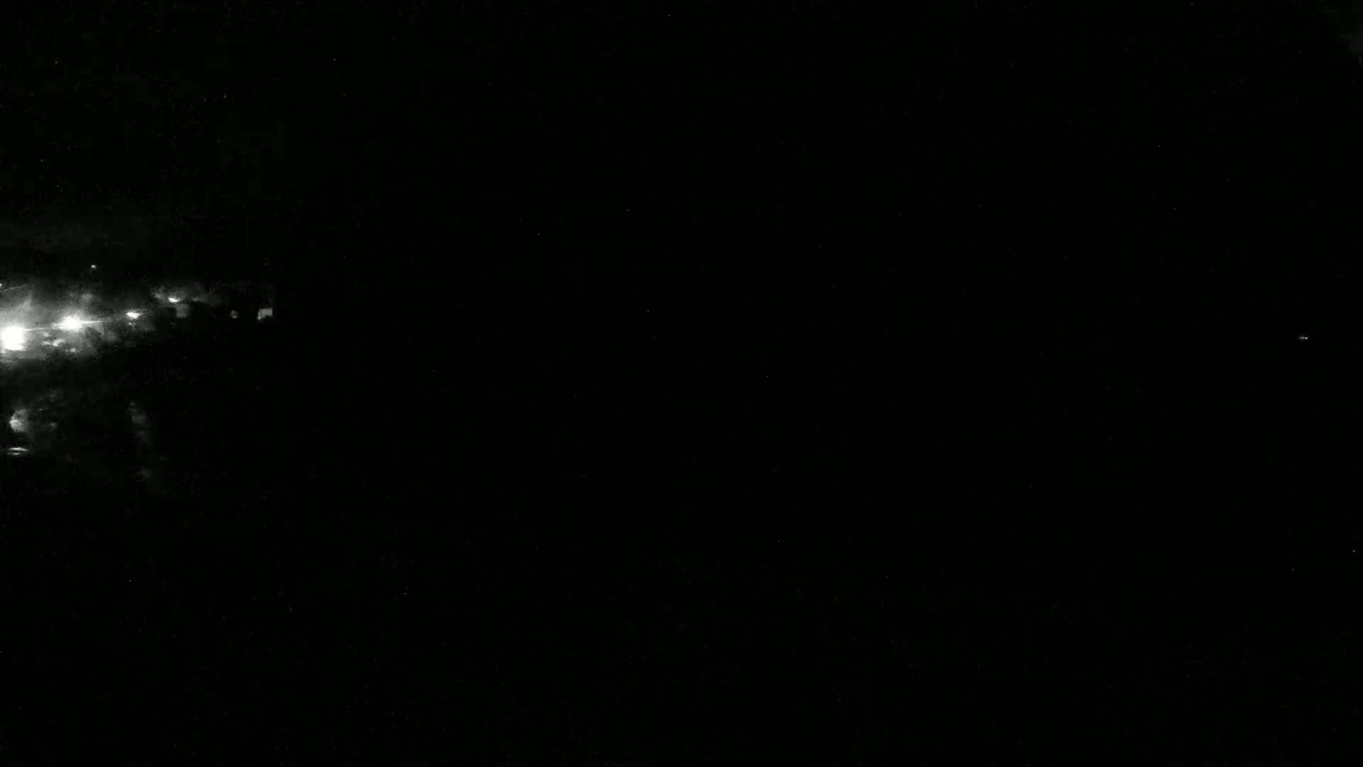 A nighttime image shows a bright, cloudy area in the left corner against a dark, mostly clear sky.