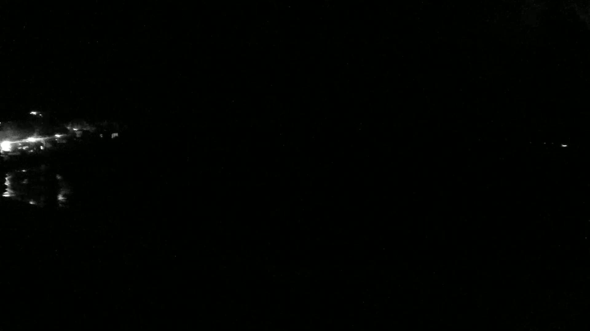 Faint lights are visible in the distance on a dark, nighttime scene.