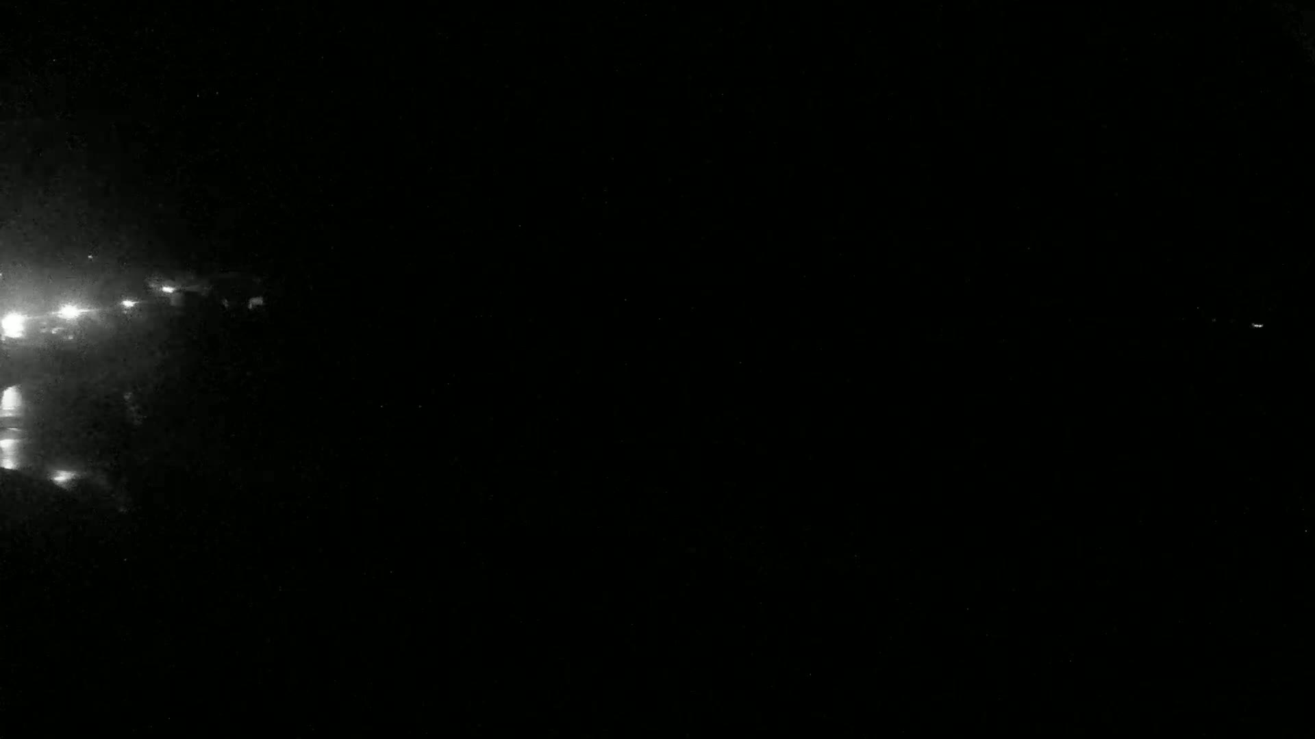 Faint lights are visible in the dark, possibly from a distant city or town at night.