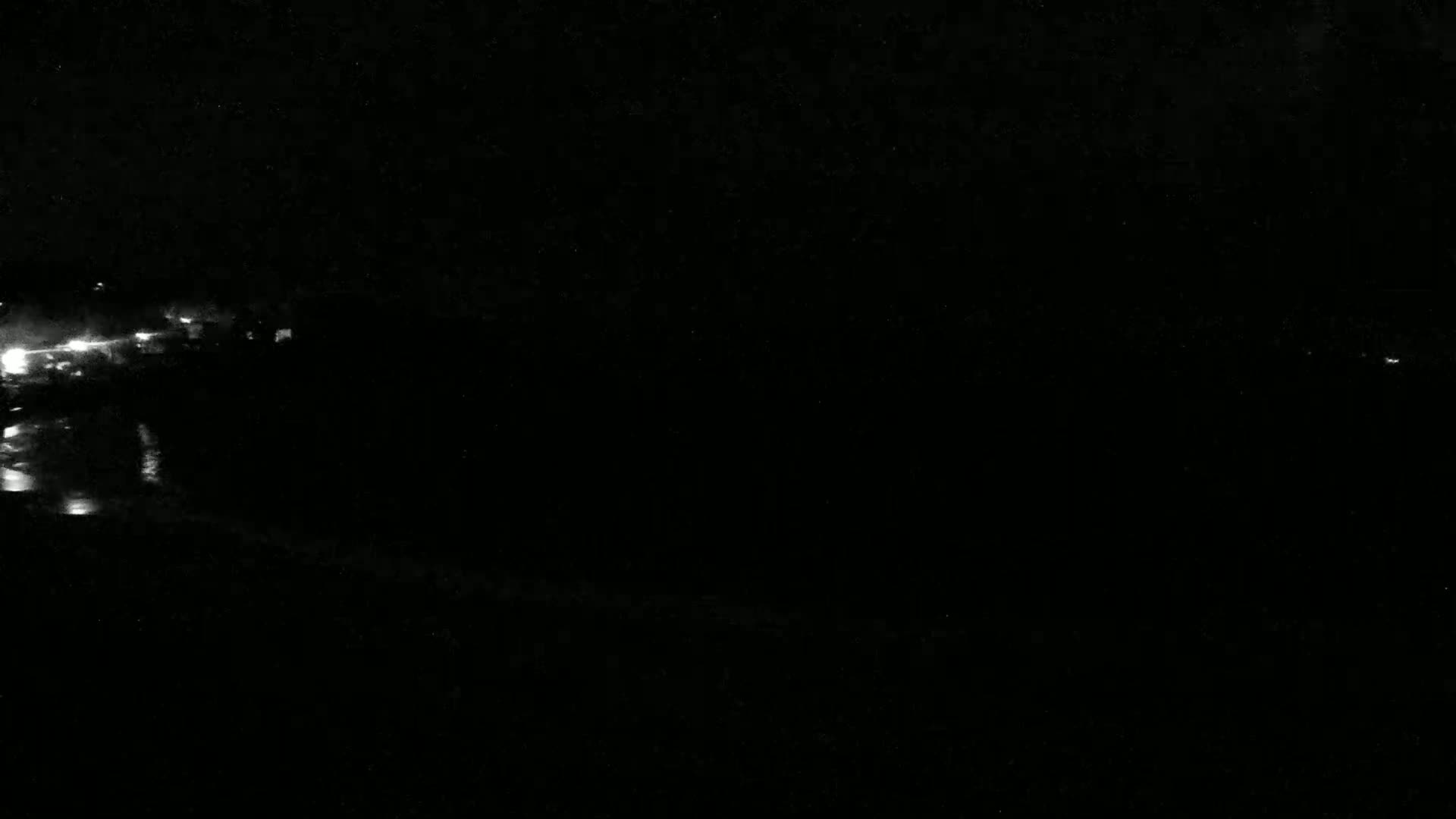 Faint lights are visible in the distance at night.