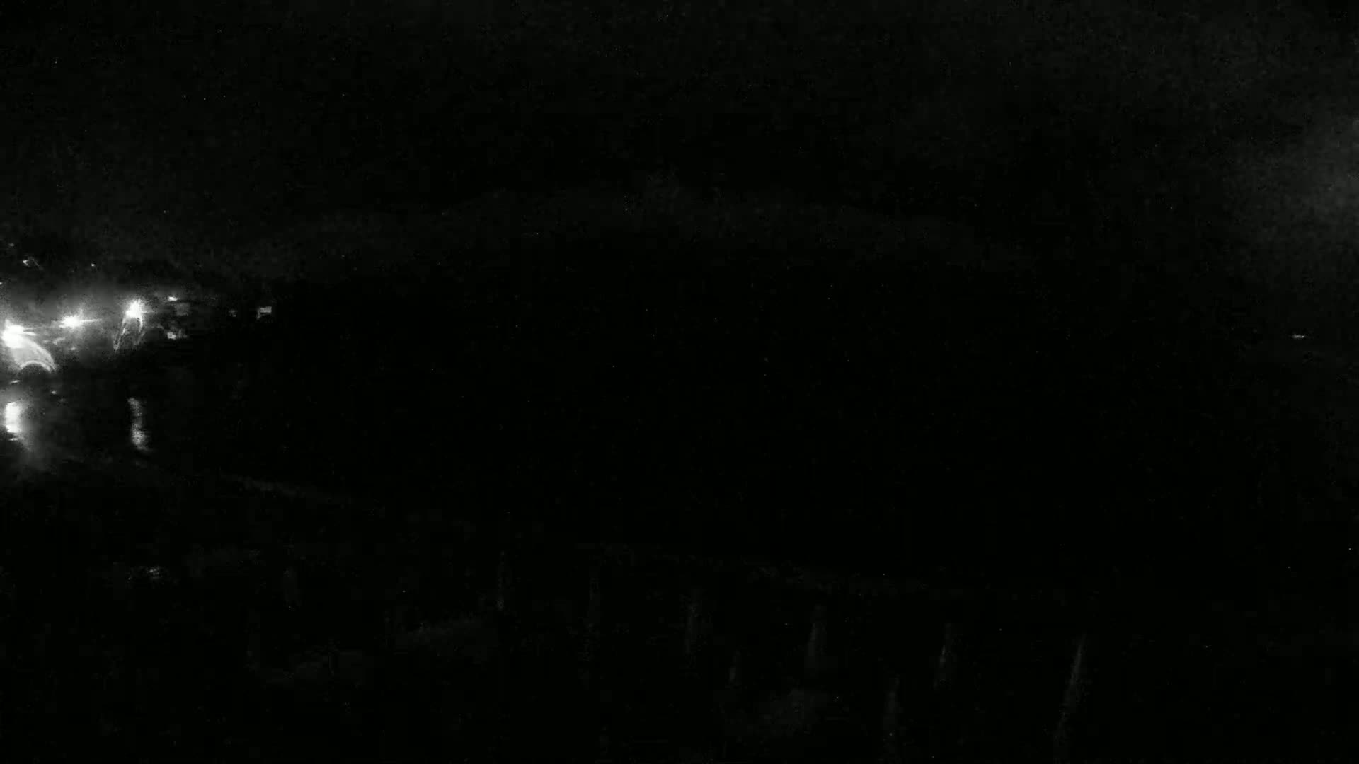 Faint white lights are visible in the dark, possibly from vehicles at night.