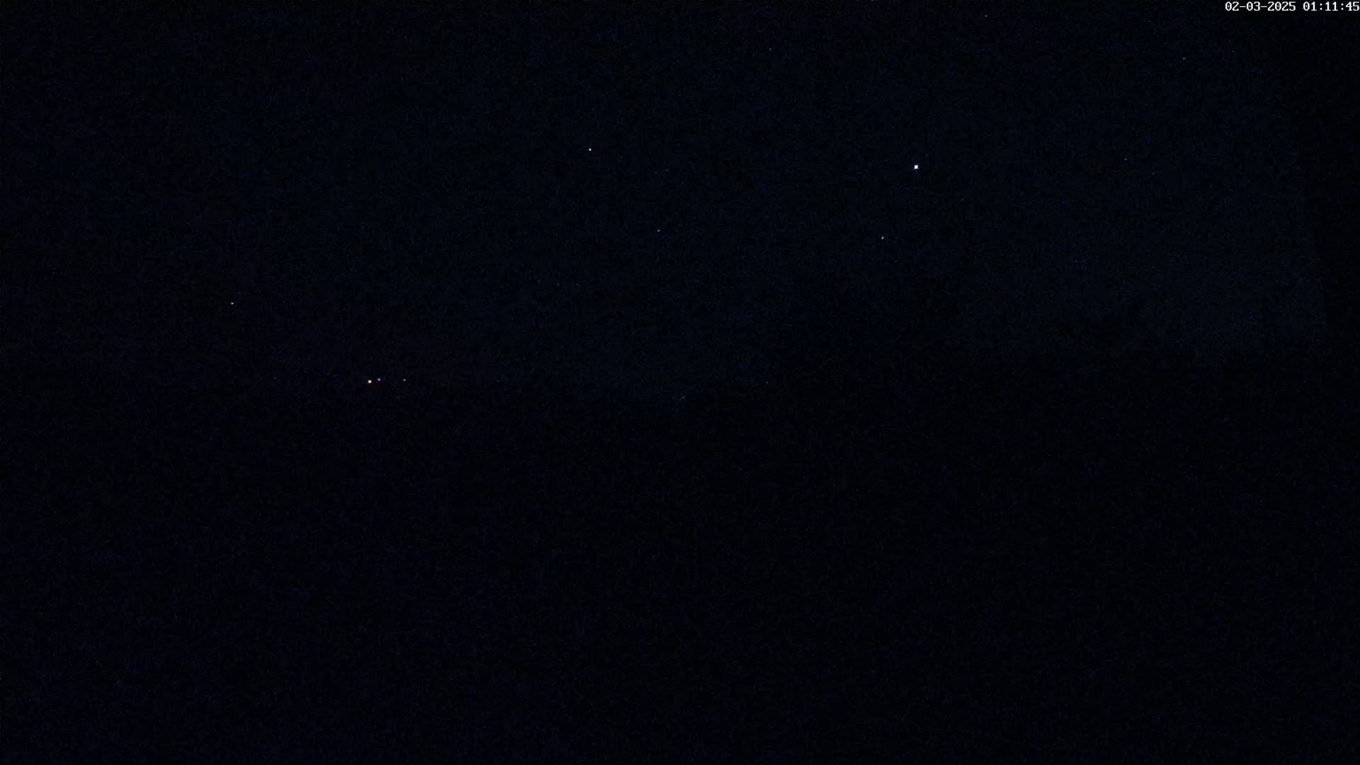 A dark night sky with a few visible stars.