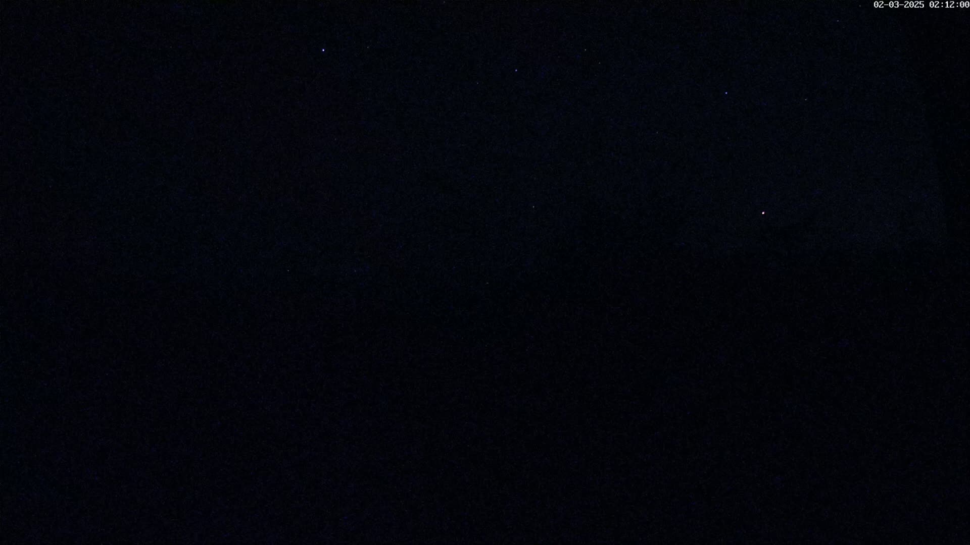 A nighttime sky shows a few visible stars against a dark, clear background.