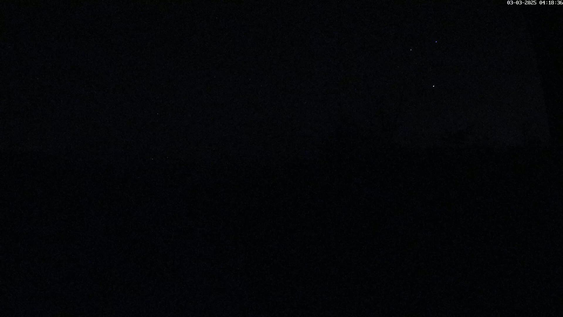 A dark night sky shows a few stars.