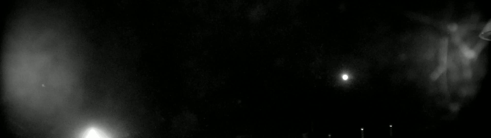 A night scene shows a bright moon and several distant lights in a dark, possibly hazy or cloudy sky.
