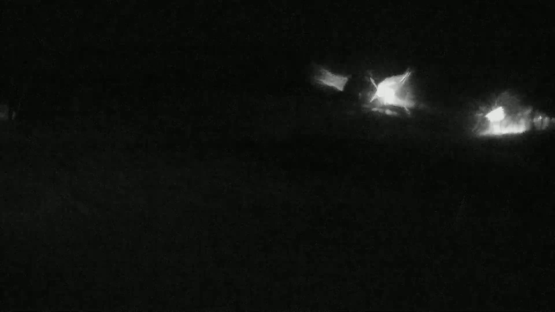 Two sets of bright headlights are visible in the dark, possibly from vehicles at night.