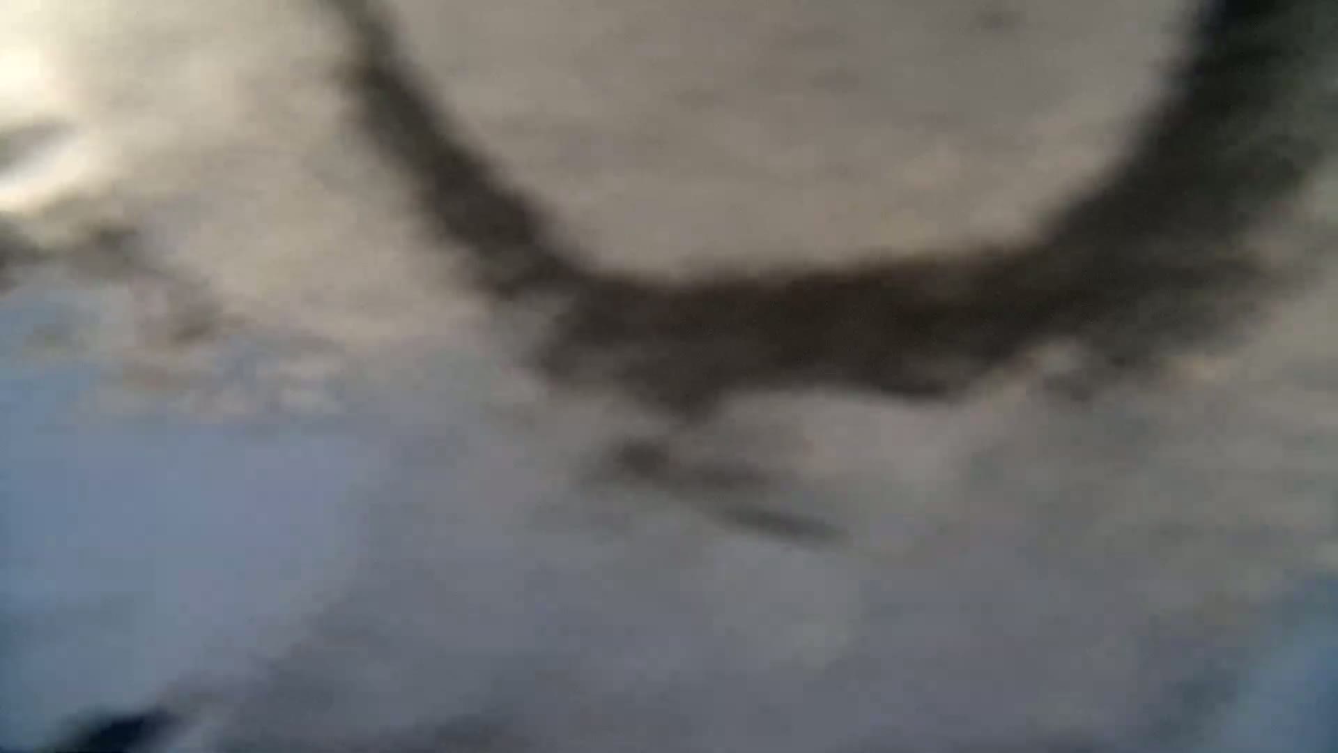 A blurry image shows a dark, curved shape against a lighter gray and blue background, possibly clouds in an overcast sky.