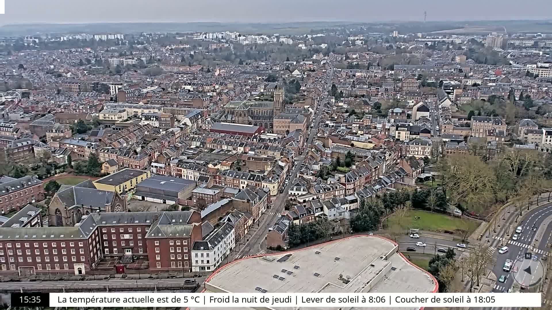 An aerial view of a dense city with a mix of residential and commercial buildings on a cloudy day.