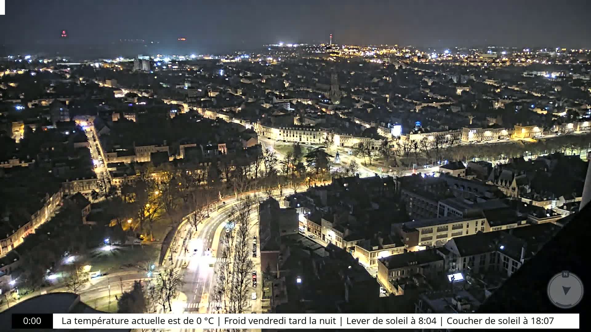 A nighttime, aerial view of a city with illuminated buildings and streets, under a clear, cold sky.