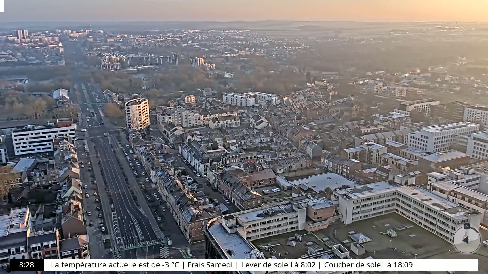 A high-angle, long shot of a city on a hazy, sunrise morning.