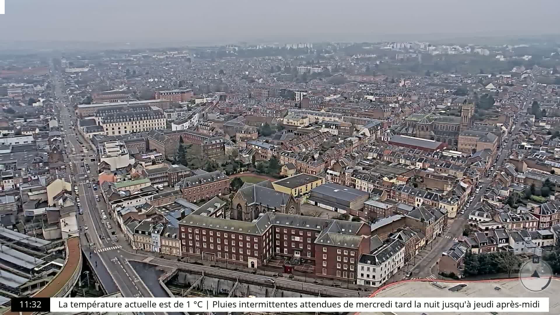 An aerial view of a densely populated city under an overcast sky.