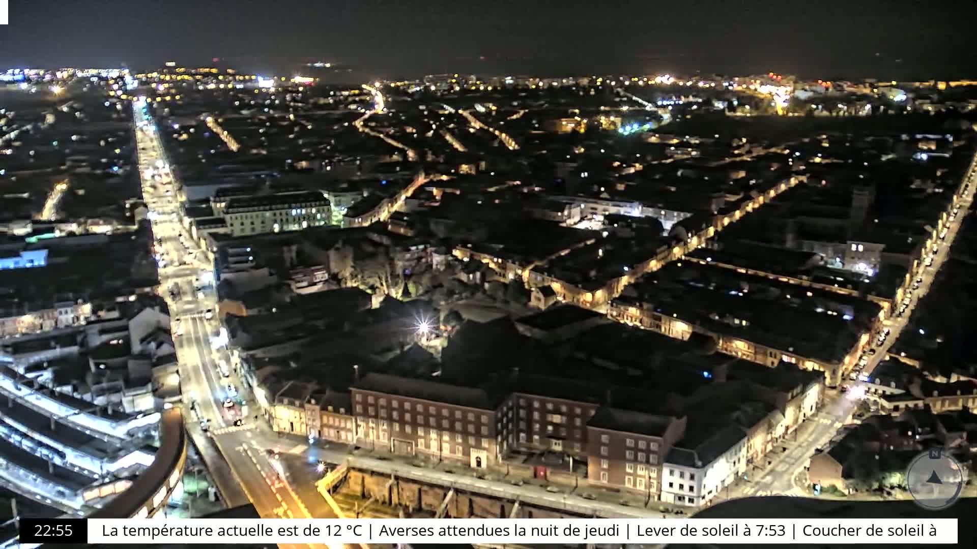 A nighttime, high-angle view of a city with illuminated streets and buildings.