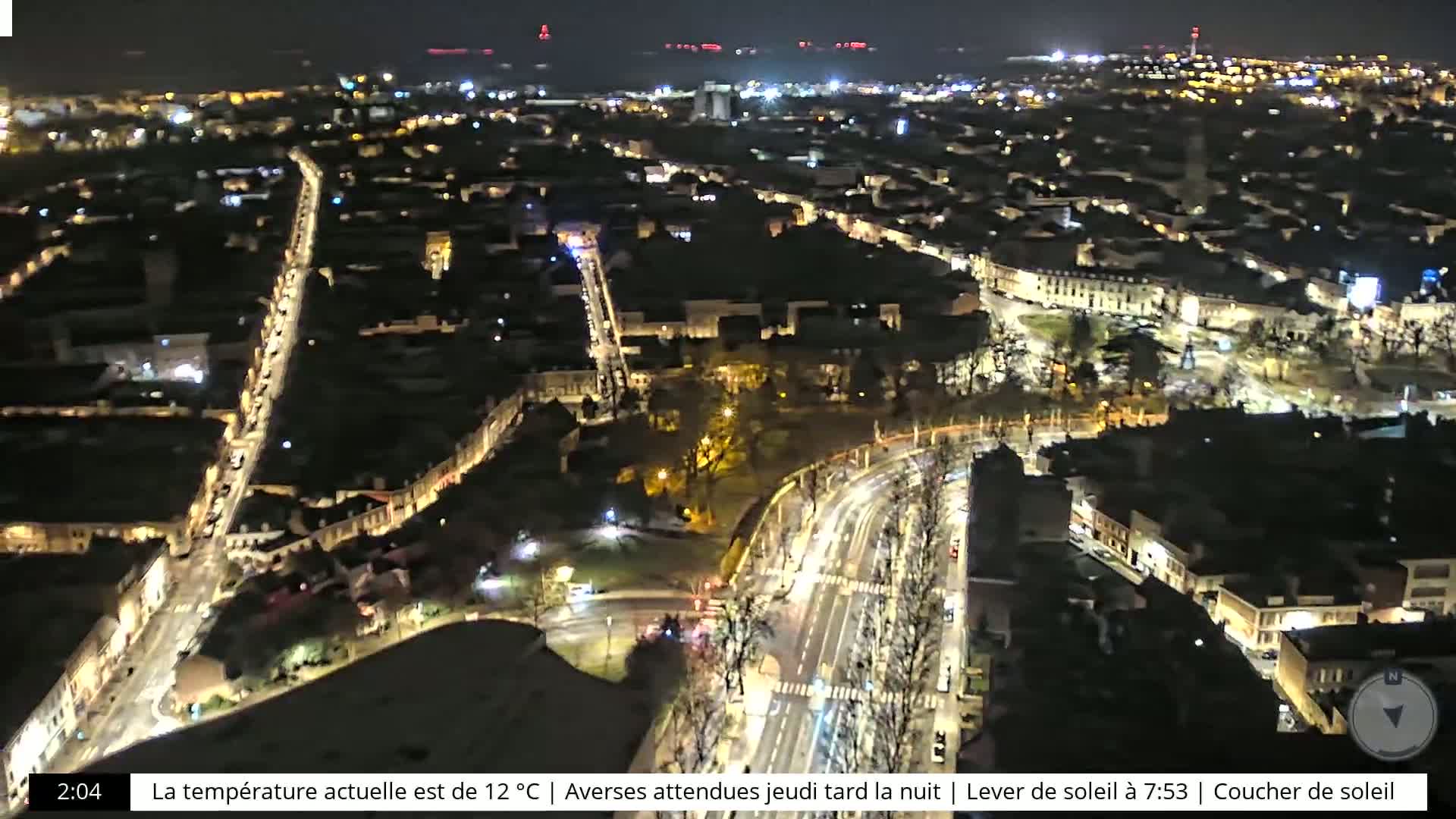 A nighttime, high-angle view of a city with illuminated streets and buildings.
