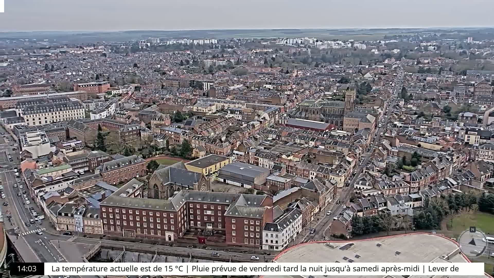 An aerial view of a densely populated city on an overcast day shows many brick buildings and streets.