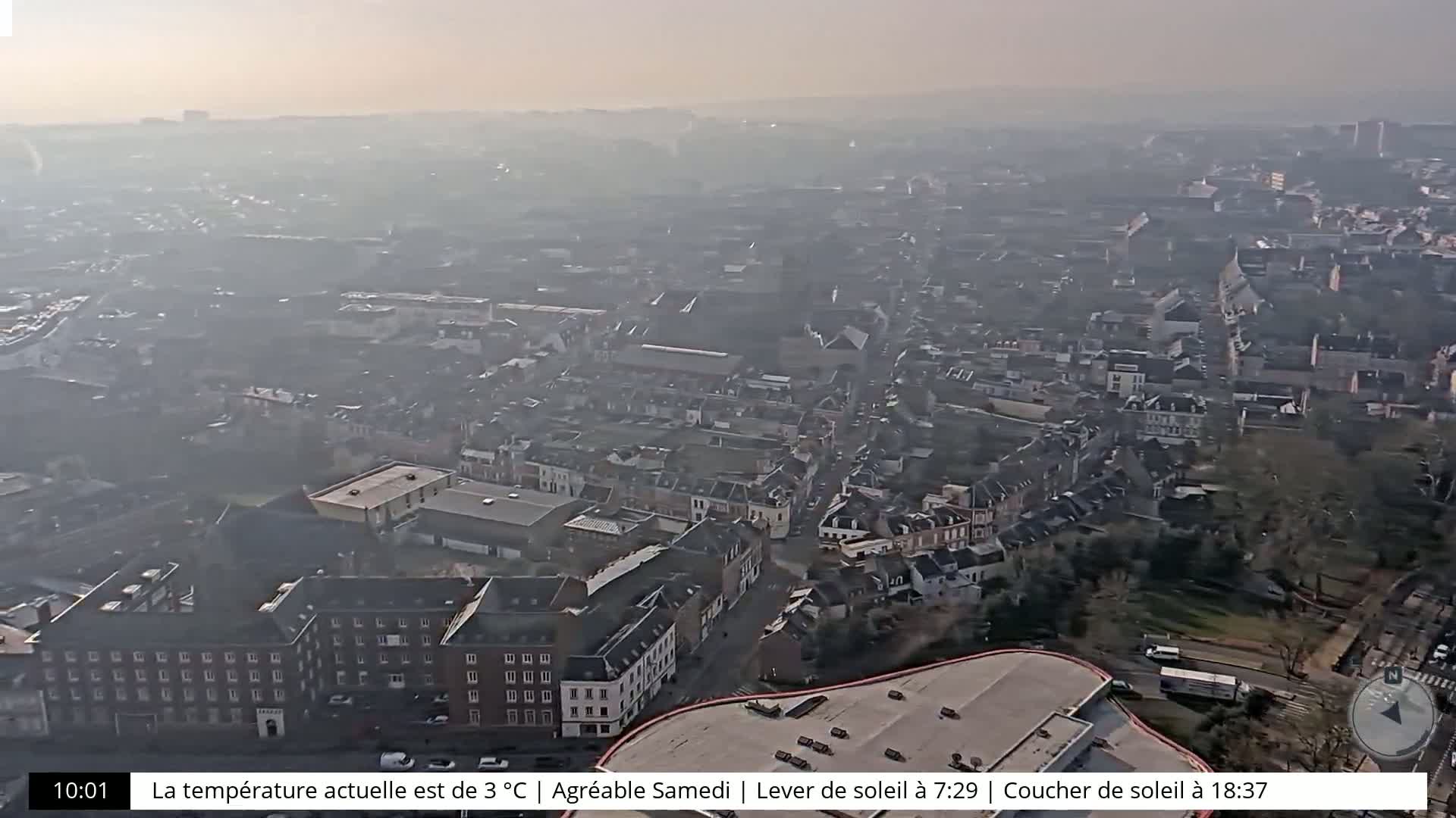 A hazy, high-angle view of a city on a partly sunny day.