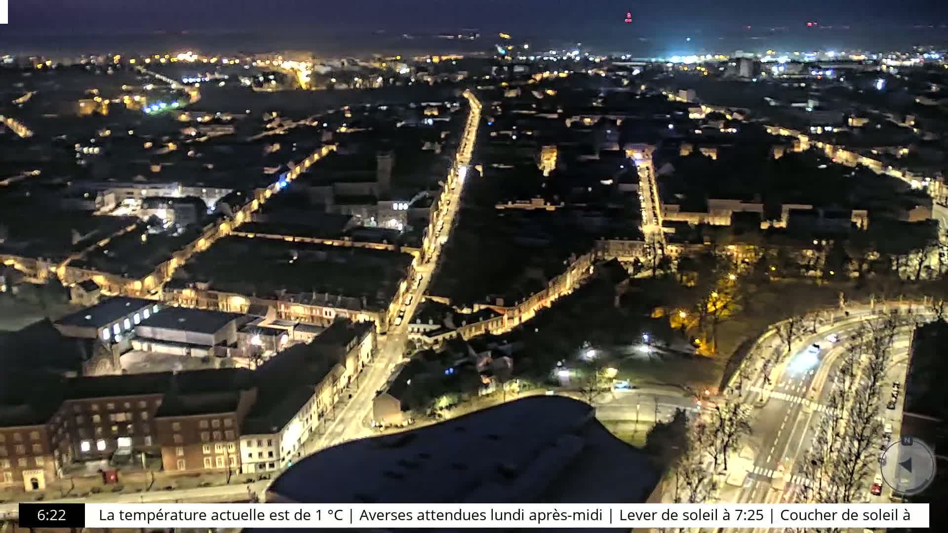 A nighttime aerial view of a city illuminated by streetlights.