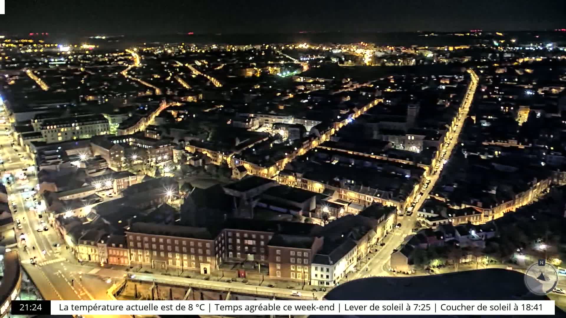 A nighttime aerial view of a city with illuminated streets and buildings.